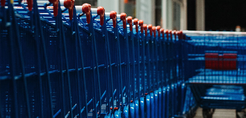 a photograph of blue grocery carts in front of a grocery store