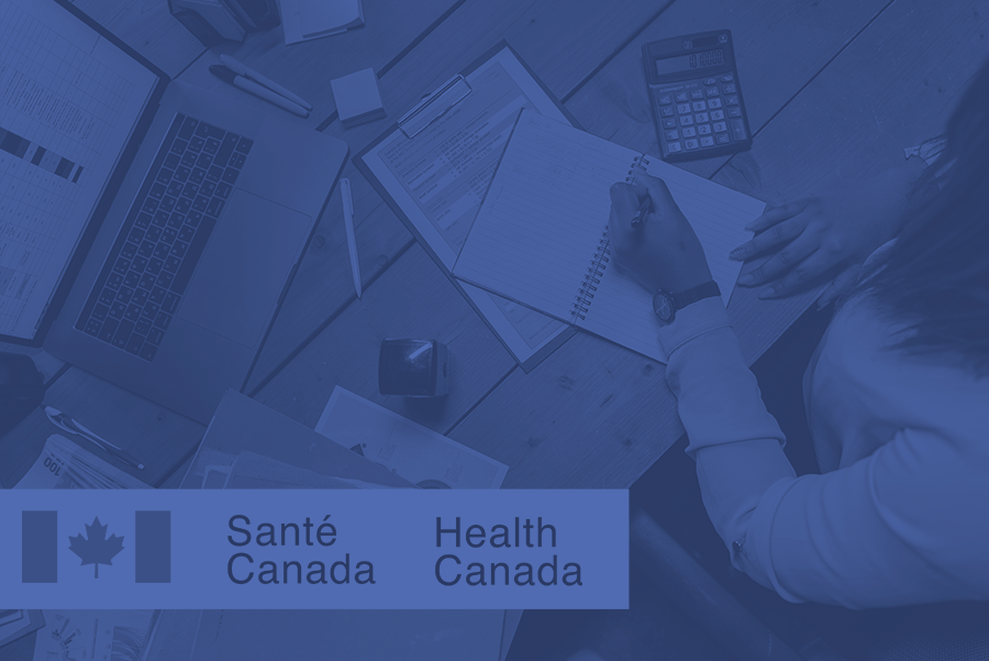 person crunching numbers at their desk with a Health Canada logo 