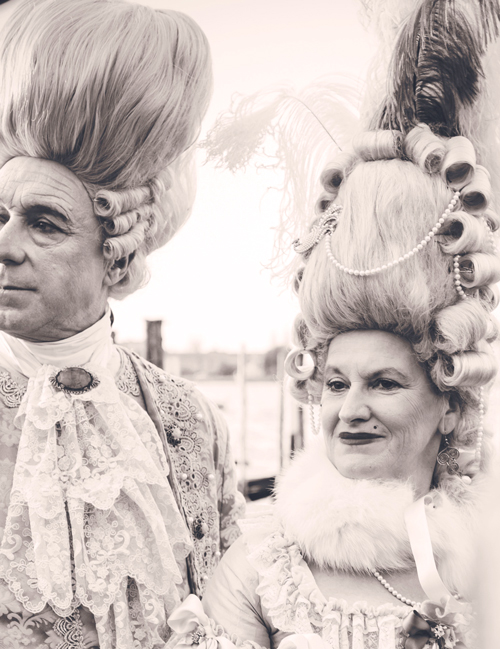 man and woman wearing very tall powdered wigs