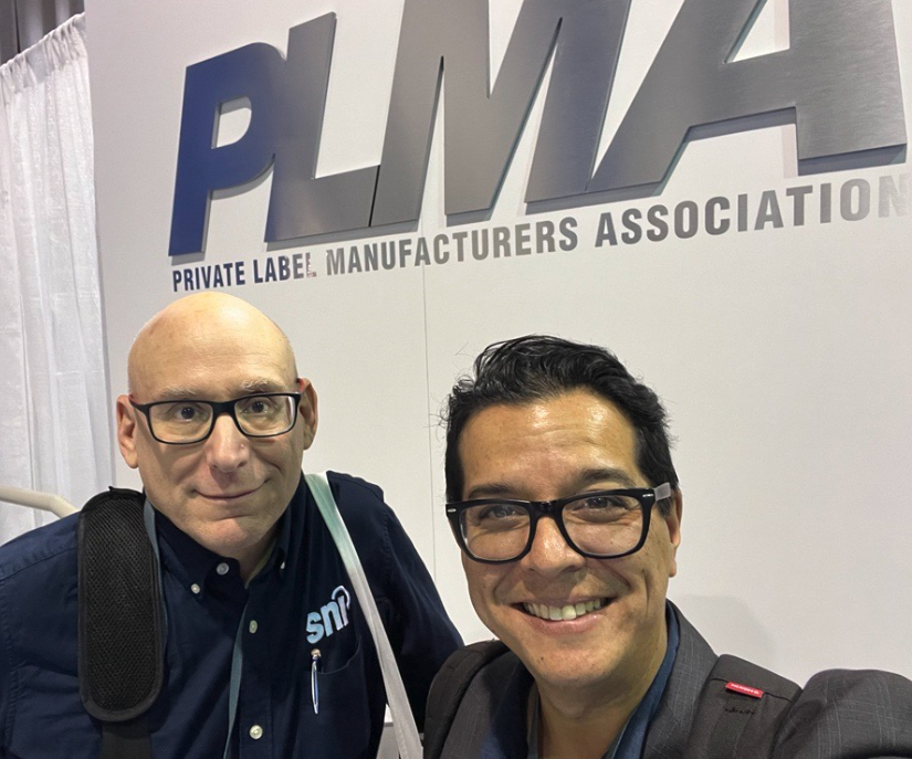 Photograph of Stuart and Marcel with the PLMA logo behind them