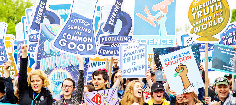 A photograph of a crowd of people with signs supporting science