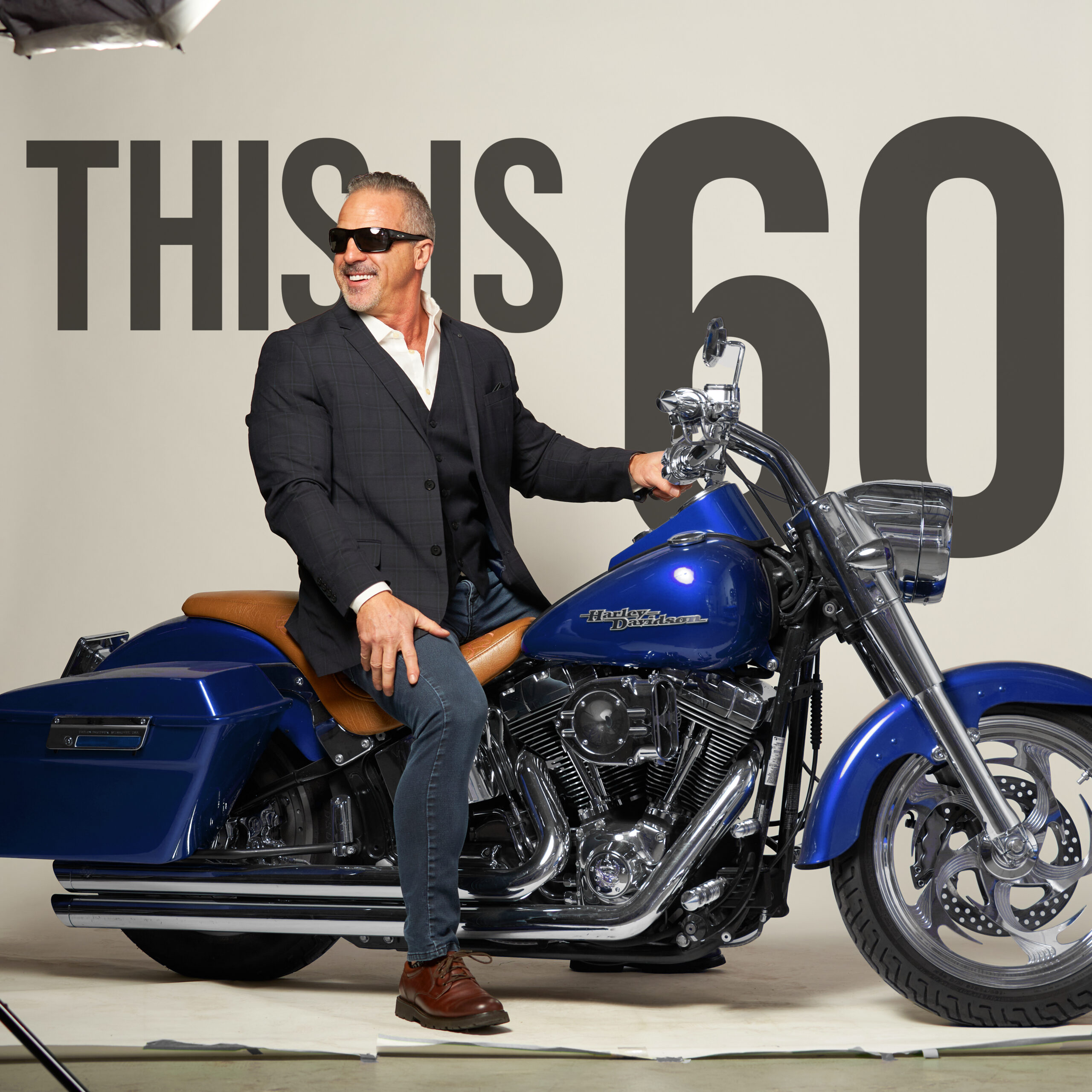 Photo of Bernie Desgagnes, President and CEO of SNI, on a motorcycle. "This is 60" displayed in the background 