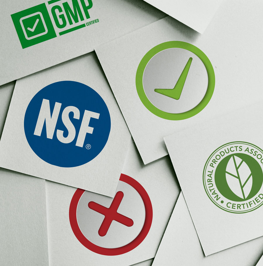 Photograph of scattered papers with various certification logos and checkmarks and x's