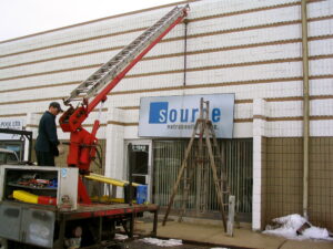 Installation of the Source Nutraceutical, Inc. sign in front of Unit 2 of 1249 Clarence Avenue in Winnipeg in September of 2004