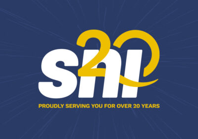 Photograph of a "20 years of service" branded SNI logo with a burst of fireworks in the background